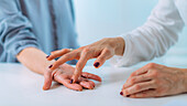 Examining the hand of a patient with carpal tunnel syndrome