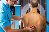 Placing markers on man's back for 3D gait analysis
