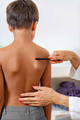 Pediatric doctor examining posture of a boy