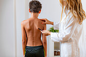Boy holding arms raised during physical examination