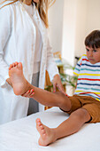 Pediatric doctor lifting a boy's leg during a medical exam
