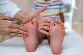 Pediatrician examining a boy's feet