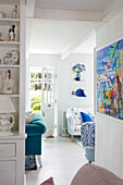 Bright living room with open passageway, blue and white furnishings and decoration