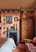 Bedroom with fireplace, wooden wardrobe and vintage-style wall decoration