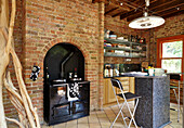 Wood burning stove and breakfast bar in open plan living room with creek stone walls