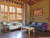 Seating area in a room with high ceilings and brick walls