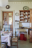 Wandregal mit Geschirr, darunter Tisch mit Schubladenaufsatz in der Küche