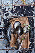 Old spoons and cloth napkins on a metal plate, rustic background