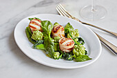 Scallops wrapped in parma ham on a green salad