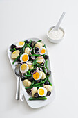Potato salad with boiled eggs, green beans, onions and grapes