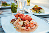 Plated lobster, shrimps and scallops with cocktail sauce