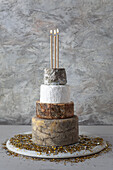 Cheese Wedding Cake - Käsesorten als mehrstöckige Hochzeitstorte arrangiert, mit Kerzen und Goldsplitter