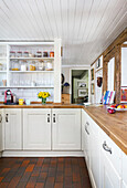 Country-style kitchen with wooden worktop and terracotta tiles