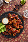 Spicy korean chicken wings with ranch sauce and celery sticks served with beer