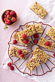 Oatmeal raspberry jam bars with crumb topping on a cooling rack