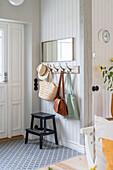 Wardrobe with wall hooks for bags and black step stool