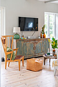 Vintage chest of drawers as TV furniture in living room with wooden floor