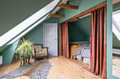 Attic bedroom in shades of green and exposed beams