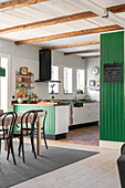 Country kitchen with green accent wall and wooden beamed ceiling