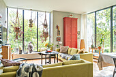 Bright living room with large windows and red cupboard