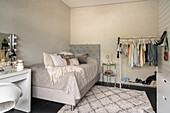 Bedroom with clothes rack, dressing table and carpet