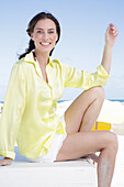 Brunette woman in yellow blouse and white shorts on the beach