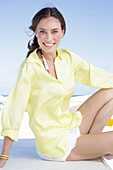 Brunette woman in yellow blouse and white shorts on the beach