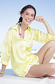 Brunette woman in yellow blouse and white shorts on the beach