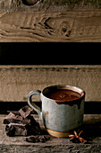 Cup of hot spicy homemade chocolate winter drink with chopped dark chocolate bar