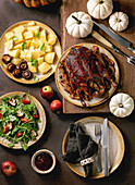 Holiday tablesetting with classic dishes roasted glazed duck with apples, boiled potatoes, green salad and sauce