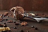 Detail of a scoop of chocolate ice cream scooped up with a ladle