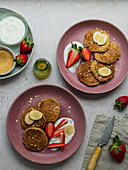 Plate with banana pancakes and a few pieces of strawberries