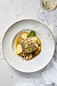 Pan seared fish with potatoes and asparagus served with white wine