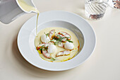 Monkfish and quails eggs in a broth