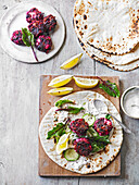 Beet covered feta on pita bread with beet greens
