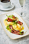Poached eggs with bacon and hollandaise sauce on muffins