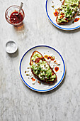 Avocado on toast topped with crumbly feta cheese and chilli oil