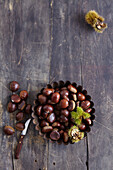 Sweet chestnuts in a metal bowl on a wooden background