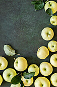 Yellow Green Apples and Leaves on Dark Green Background