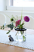 Flower vase on table with patterned tablecloth