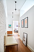 White hallway with leather bench and modern print