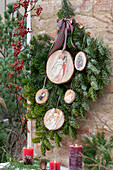 Nostalgically decorated wooden discs on fir branches (Abies nobilis)