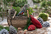 Basket with conifer branches (Coniferales), cones, and rolls of yarn