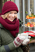 Woman dressed in winter clothes with a cup of mulled wine