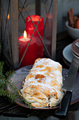 Curd filled strudel, lantern with red candles in the background