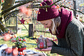 Blonde woman with winter hat and scarf holding lantern