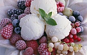 Vanilla ice cream with frozen berries and mint in a marble bowl