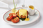 Fishcake on a bed of spinach served with a hollandaise sauce