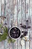 Bowl of blackberries on a wooden background