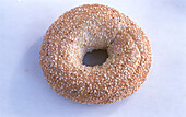 A bagel with sesame seeds on a light background